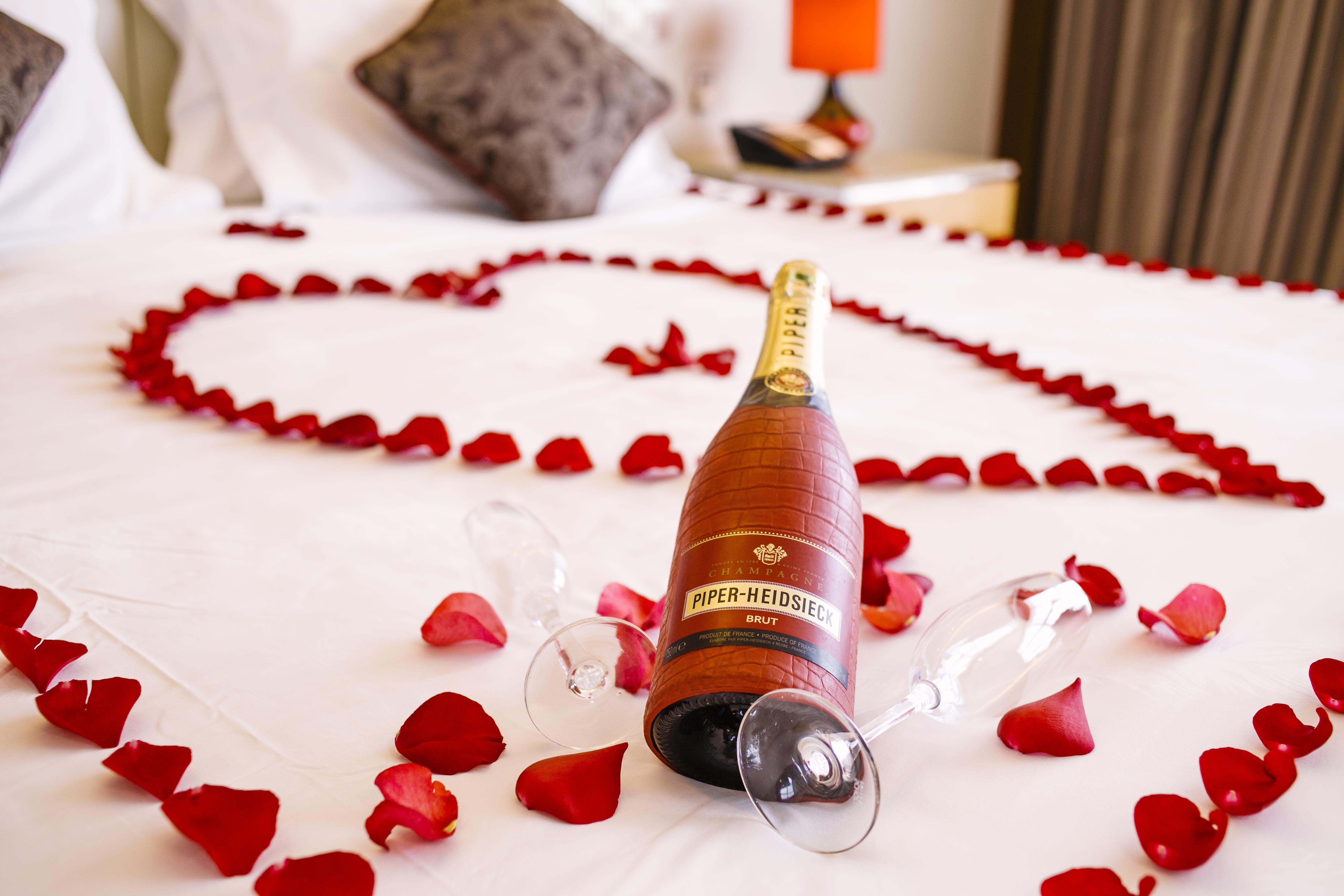 The Boma Nairobi Hotel Exterior photo A bottle of champagne and rose petals on a bed