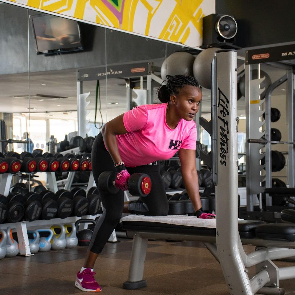 The Boma Nairobi Hotel Exterior photo A woman performing a dumbbell row